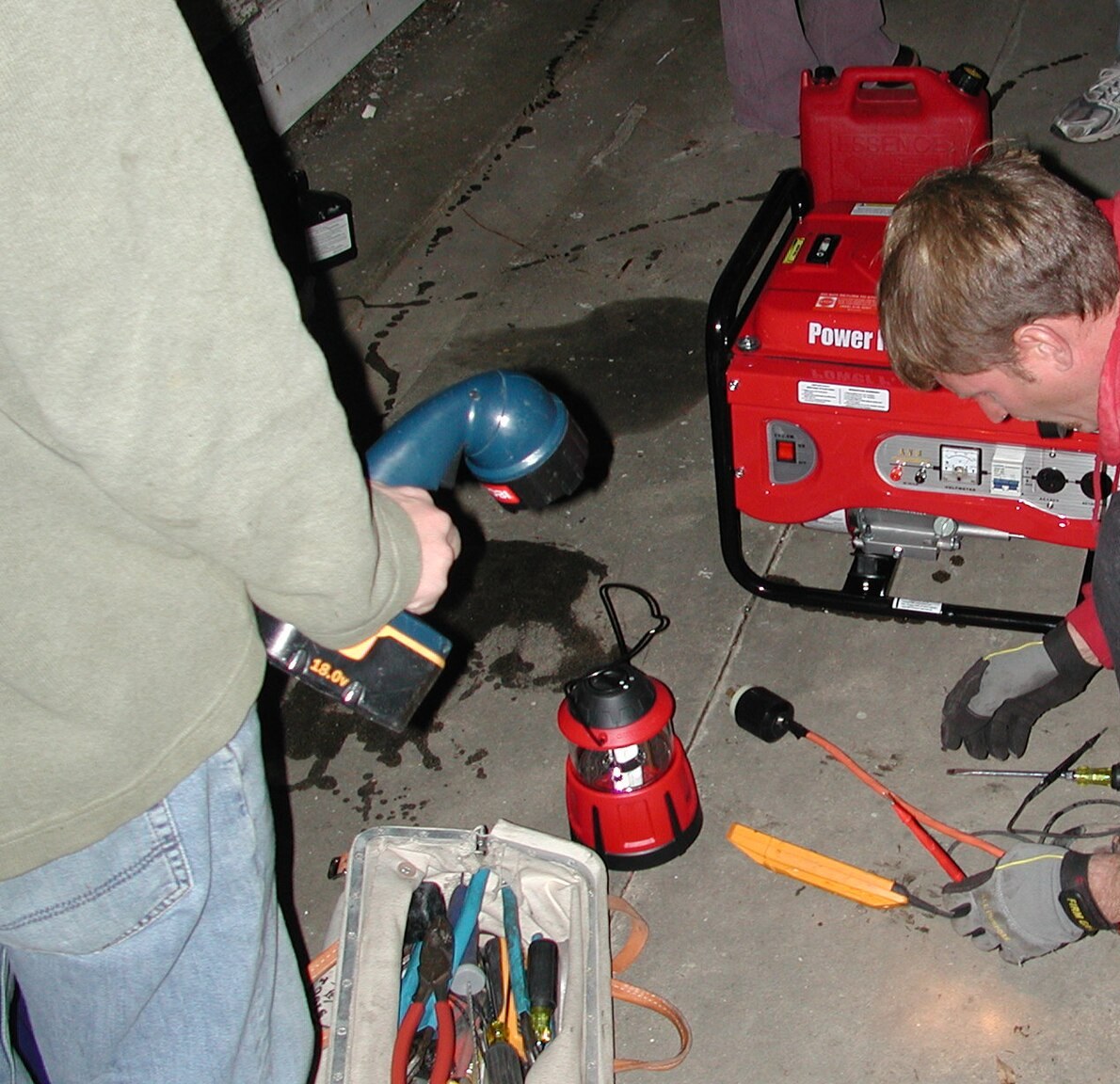 Electrician working by lantern light during an outage